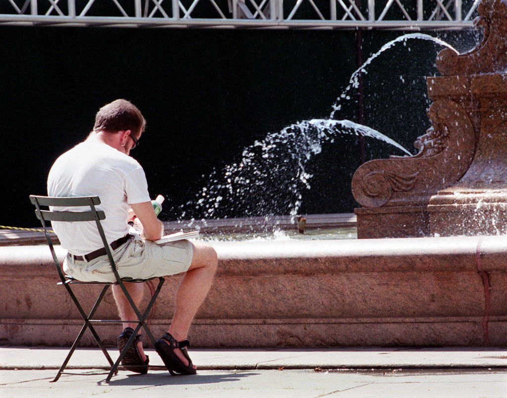 A man reads a book by a fountain 06 July, 1999, in