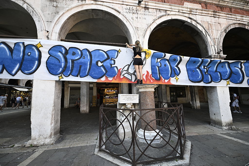 Lo slogan ufficiale della protesta, dipinto su uno striscione: "No Space for Bezos"